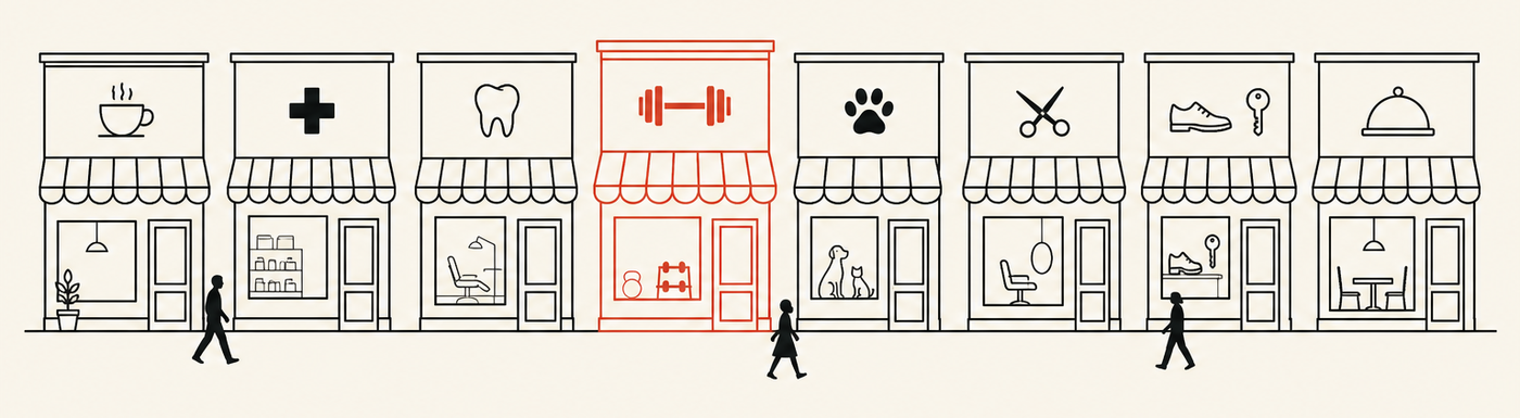 A row of eight neighborhood storefronts — coffee shop, pharmacy, dentist, gym, vet, salon, repair shop and restaurant — with one picked out in red.